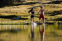 Young couple bathing in lake Laghi della Valletta, Gotthard, Canton of Ticino, Switzerland