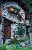 farmhouse with flower decoration and roses, Savogno, Valchiavenna, Bergell, Italy