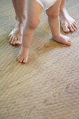Father standing behind baby, close-up feet, , Carinthia, Austria