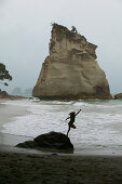 Girl jumping into waves, Cathedral Cove, hiking track to Cathedral Cove Beach, near Hahei, eastcoast, Coromandel Peninsula, North Island, New Zealand