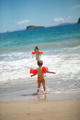 Young girls (5 and 2.5 y.) taking a swim at Hahei Beach, near Hahei, eastcoast, Coromandel Peninsula, North Island, New Zealand