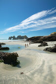 Hiking on Wharariki Beach, tidal pools, low tide, near Puponga, northwestern coast of South Island, New Zealand