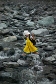 Girl crossing melting water, hiking at Franz Josef Glacier, Westland National Park, Westcoast, South Island, New Zealand