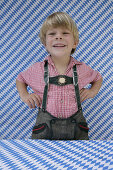 Boy (4-5 years) wearing leather trousers laughing at camera, Munsing, Upper Bavaria, Bavaria, Germany