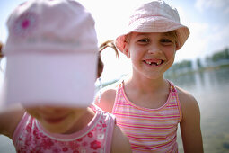 Girls (7-8 years) with tooth gap smiling at camera, Lake Staffelsee, Upper Bavaria, Germany