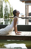 Woman doing Yoga exercises near a pool, Wellness, Relaxation, Health