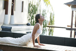 Woman doing Yoga exercises near a pool, Wellness, Relaxation, Health