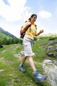 Female hiker on the way to a chapel, Heiligenblut, Hohe Tauern National Park, Carinthia, Austria