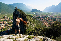 Rock climber at the summit with climbing rope, Arco, Lake Garda, Trento, Italy