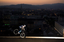 Man trial biking on edge of a highrise building, Linz, Upper Austria, Austria