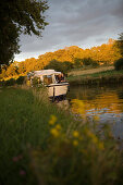 Houseboat Moored on Canal Bank at Sunset, Crown Blue Line Calypso Houseboat, Canal de la Marne au Rhin, near Heming, Alsace, France