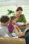 Family reading a book, Munich, Germany