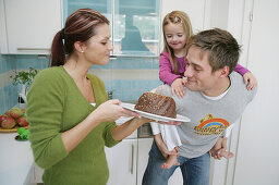 Young family with a chocolate cake in a domestic kitchen, Munich, Germany