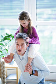 Father giving daughter (3-4 years) piggyback, Munich, Germany