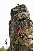 Personen klettern an einem Sandsteinfelsen, Elbsandsteingebirge, bei Rathen, Sachsen, Deutschland