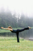 Woman performing yoga along Wark Lake. Ketchikan, Alaska. USA