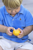 toddler peeling tangerine