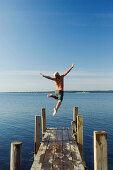  Action, Activity, Amusement, Back view, Bathing suit, Bathing suits, Blond, Blonds, Boy, Boys, Caucasian, Caucasians, Child, Children, Color, Colour, Contemporary, Daytime, Determination, Dive, Diving, Dock, Docks, Exterior, Fair-haired, Free, Freedom, F