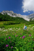 Wanderer im Abstieg durch die Blumenwiesen im Isstal, Karwendel, Hall, Tirol, Österreich