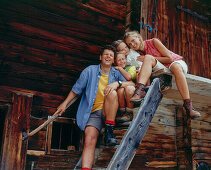 Familie sitzt auf einer Treppe vor einer Almhütte, Eng, Kleiner Ahornboden, Tirol, Österreich