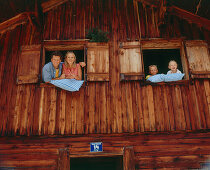 Family looking out of window of an alp lodge, Eng, Kleiner Ahornboden, Tyrol, Austria