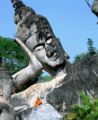 Monk at the giant Buddha, Buddha Park. Vientiane. Laos