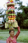 Woman carrying offers to temple during the Galungan Festival. Bali, Indonesia