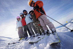 Children wearing ski helmet and ski googles standing side by side, skiing region Sonnenkopf, Vorarlberg, Austria