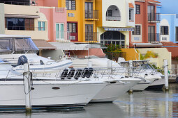 Boats are moored at Palmas del Mar harbour in front of colourful houses, Palmas del Mar, Puerto Rico, America