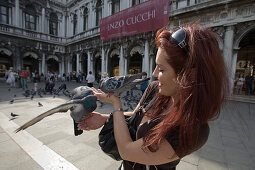 Woman feeding pigeons on Piazza San Marco, Venice, Veneto, Italy