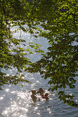 Junge Familie badet an einem Sommertag am Wesslinger See, Bayern, Deutschland
