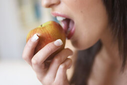 Close up of woman about to bite into an apple