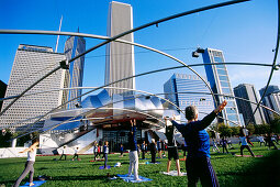 Gymnastik am Jay Pritzker Pavillon von Frank Gehry im Millenium Park, Chicago, Illinois, USA