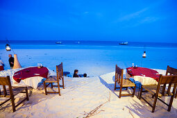 People passing a beach restaurant, The Sands, at Nomad, Diani Beach, Kenya