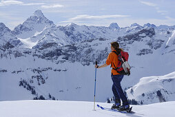 Skitourgeherin genießt Ausblick auf die Allgäuer Alpen, Bayern, Deutschland