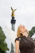 Angel, young woman with wings at the Friedensengel, Golden angel statue, Munich, Bavaria, Germany
