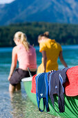 Two young women, girls, sitting on a boat, feet in the water, Lake Walchensee, Upper Bavaria, Bavaria, Germany