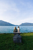 Zwei junge Frauen sitzen am Ufer vom Walchensee, Oberbayern, Bayern, Deutschland