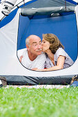 Senior couple lying in their tent, Woman kissing man, Holiday, Bavaria, Germany