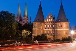 The illuminated Holstentor with St. Mary's church at night, Luebeck, Schleswig Holstein, Germany, Europe