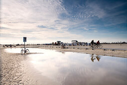 Cyclists at beach, St. Peter-Ording, Schleswig-Holstein, Germany