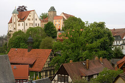Hohnstein castle above trees and half-timbered houses, Saxon Switzerland, Elbsandsteingebirge, Saxony, Germany, Europe