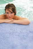 20 yr old woman leaning on hands at edge of spa
