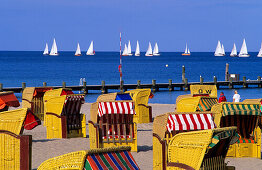 Strandkörbe im Sonnenlicht und Segelboote auf dem Meer, Travemünde, Schleswig-Holstein, Deutschland, Europa