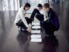 Three businesswomen reading documents, Munich, Bavaria, Germany
