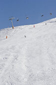 Skifahrer und Schneespuren unter einer Seilbahn, Schnalstal, Südtirol, Italien