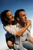 Man giving woman piggyback, Ambach, Bavaria, Germany