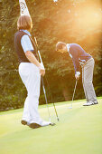 Zwei Männer spielen Golf, Straßlach-Dingharting, Bayern, Deutschland