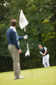 Zwei Männer spielen Golf, Straßlach-Dingharting, Bayern, Deutschland