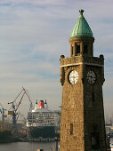 Clock tower and cruise ship Queen Mary 2 at the shipyard, Hanseatic City of Hamburg, Germany